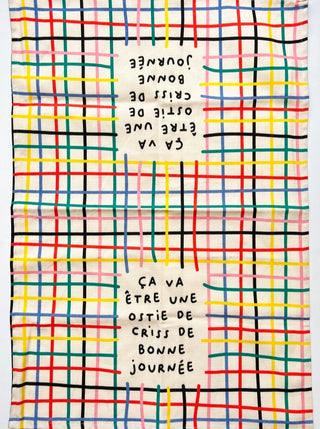 Linge à vaisselle rayé avec les couleurs primaires inscrit: ça va être une ostie de criss de bonne journée. Parfait idée cadeau pour femme. Fait au Québec.